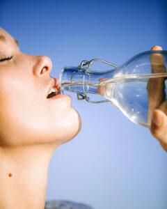 Person drinking a bottle of water to stay hydrated